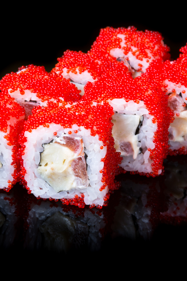 Японские роллы с красной икрой на черном фоне 