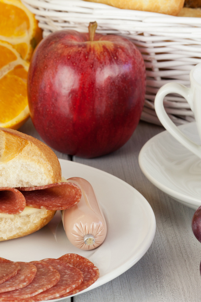 Бутерброд с сыром и колбасой и сок с яблоком и виноградом на завтрак