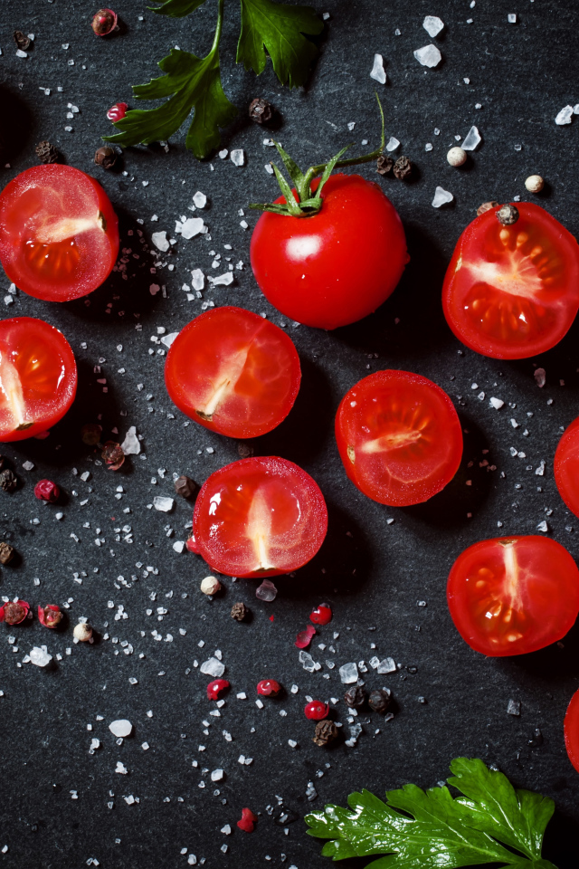 Помидоры на столе с зеленью петрушки и специями