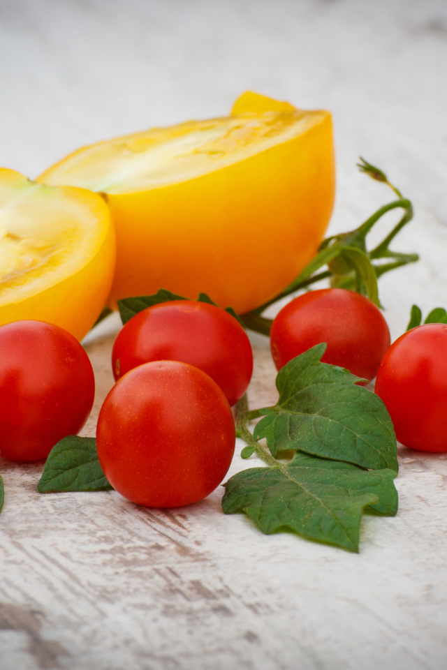 Желтые и красные помидоры на деревянной доске