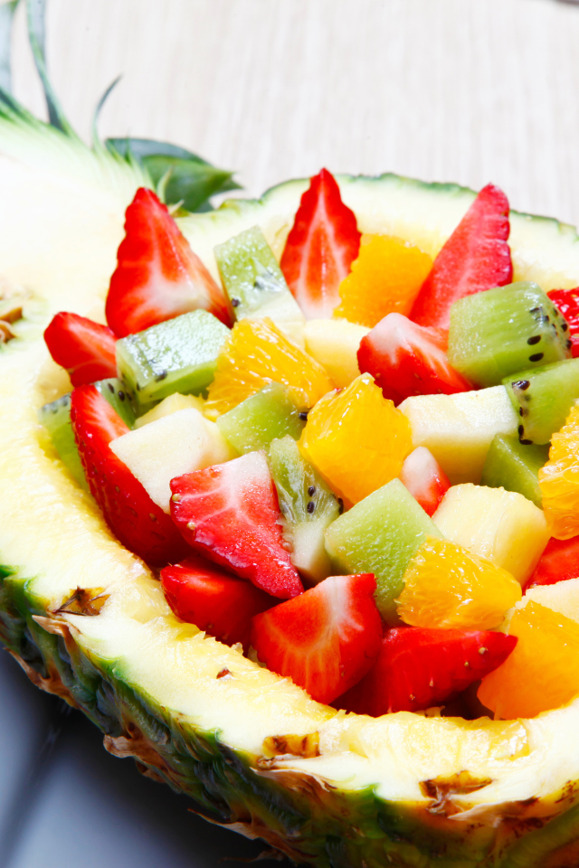 Фруктовый салат из цитрусовых  в тарелке из свежего ананаса 