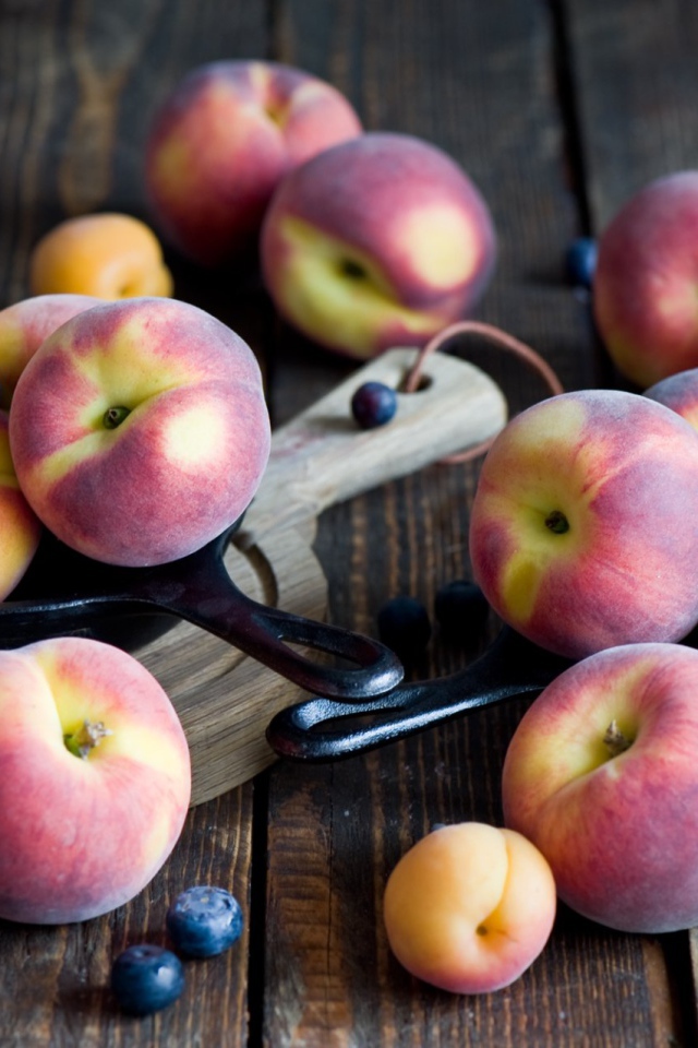 Сочные свежие персики, абрикосы и черника на столе