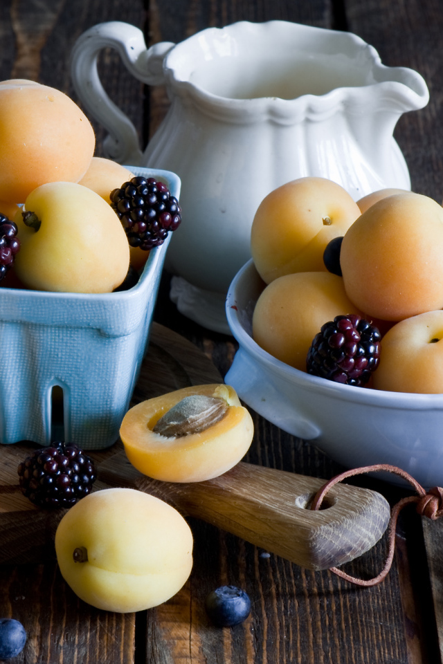 Спелые абрикосы и ягоды на столе 