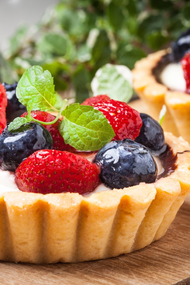 Пирожное с кремом и свежими ягодами черники и клубники