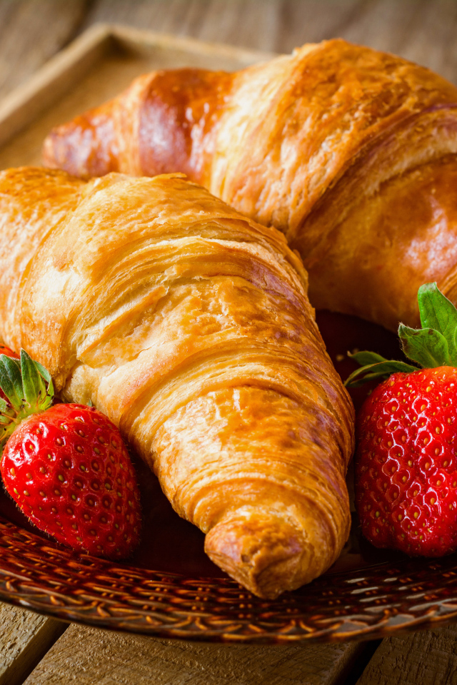 Два свежих круассана со свежей клубникой