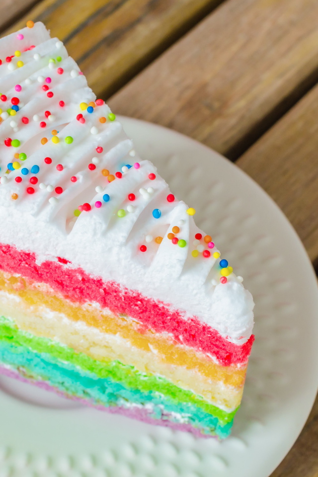 Кусок разноцветного торта на белой тарелке