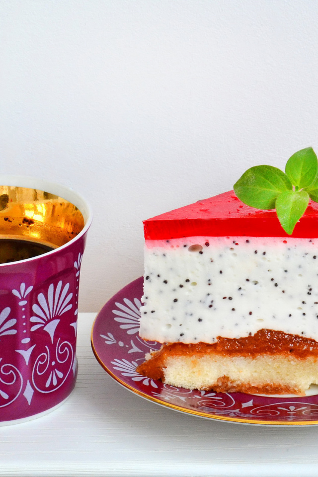 Кусок пирожного на тарелке с чашкой чая