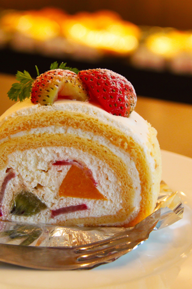 Кусок сладкого бисквитного рулета с клубникой 