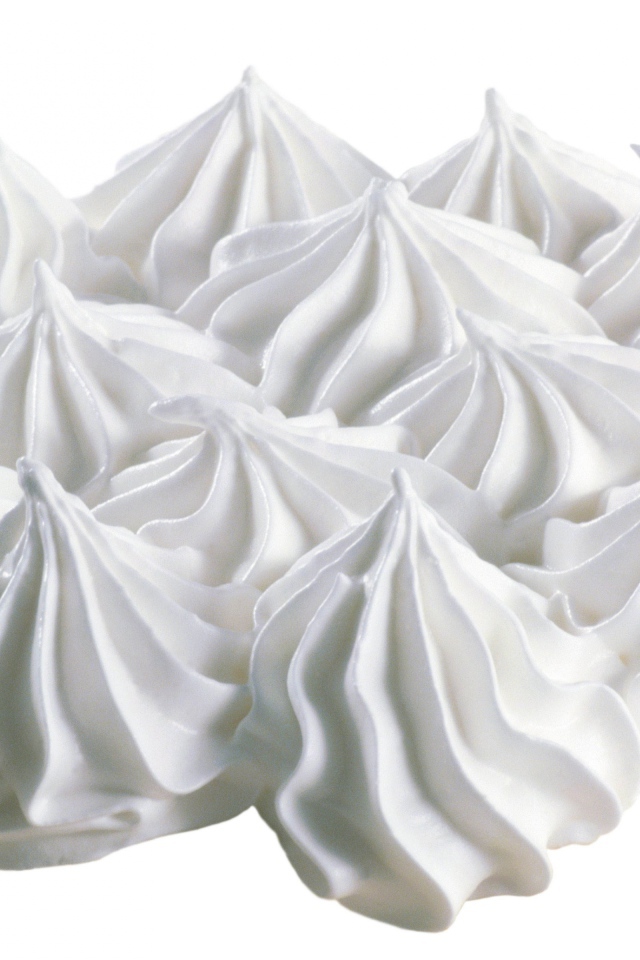 Воздушные взбитые сливки на белом фоне