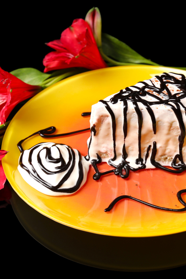 Аппетитное пирожное с шоколадом и цветком альстремерия на черном фоне