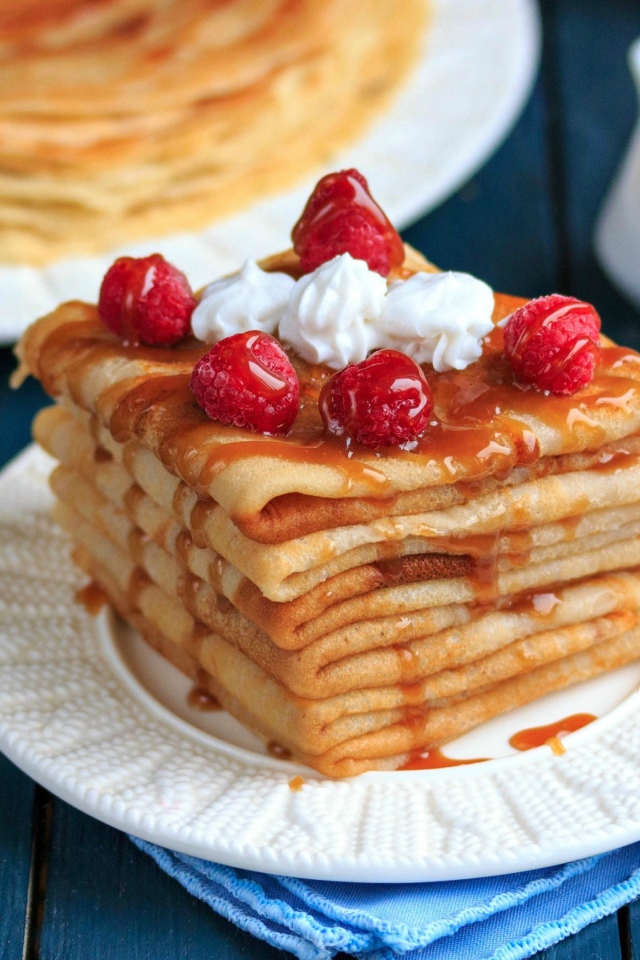 Аппетитные тонкие блинчики с ягодами малины и сиропом