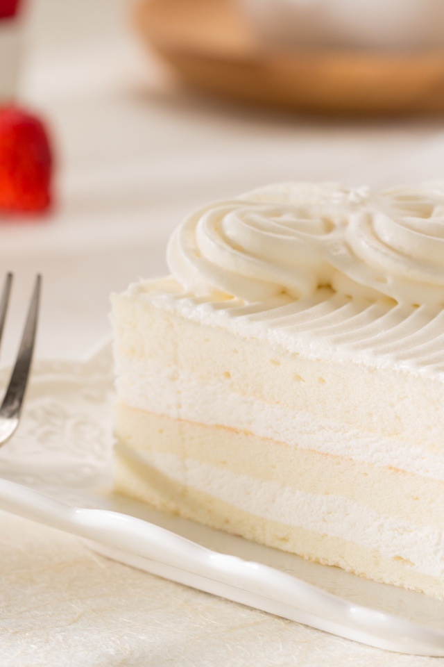 Аппетитный кусок бисквитного торта со сливочным кремом