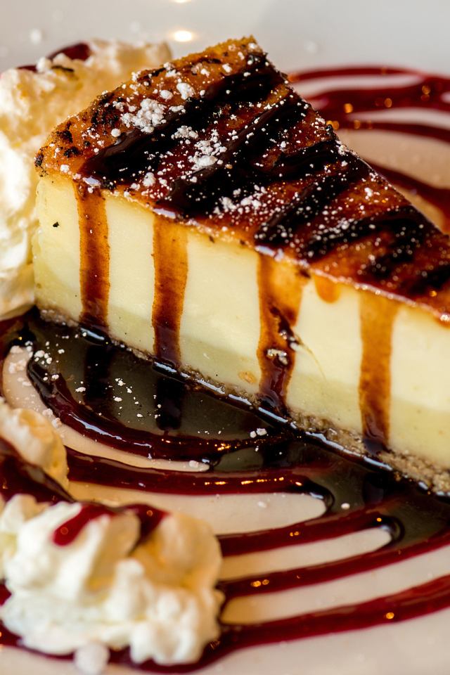 Аппетитный кусок чизкейка со сливками и клубничным джемом