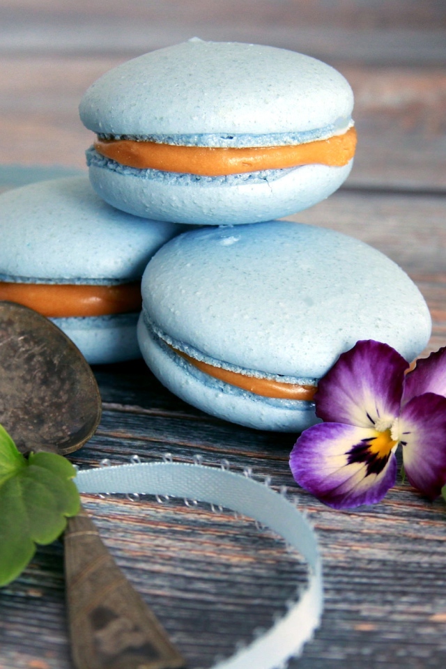 Голубые макаруны на столе с цветком 