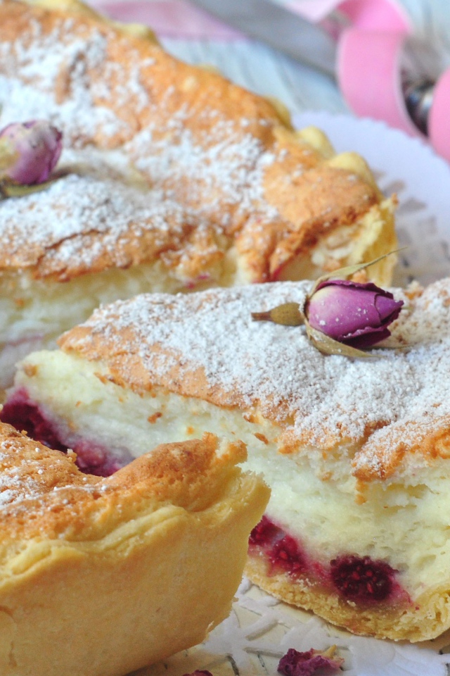 Пирог с суфле и малиной посыпанный сахарной пудрой и цветами