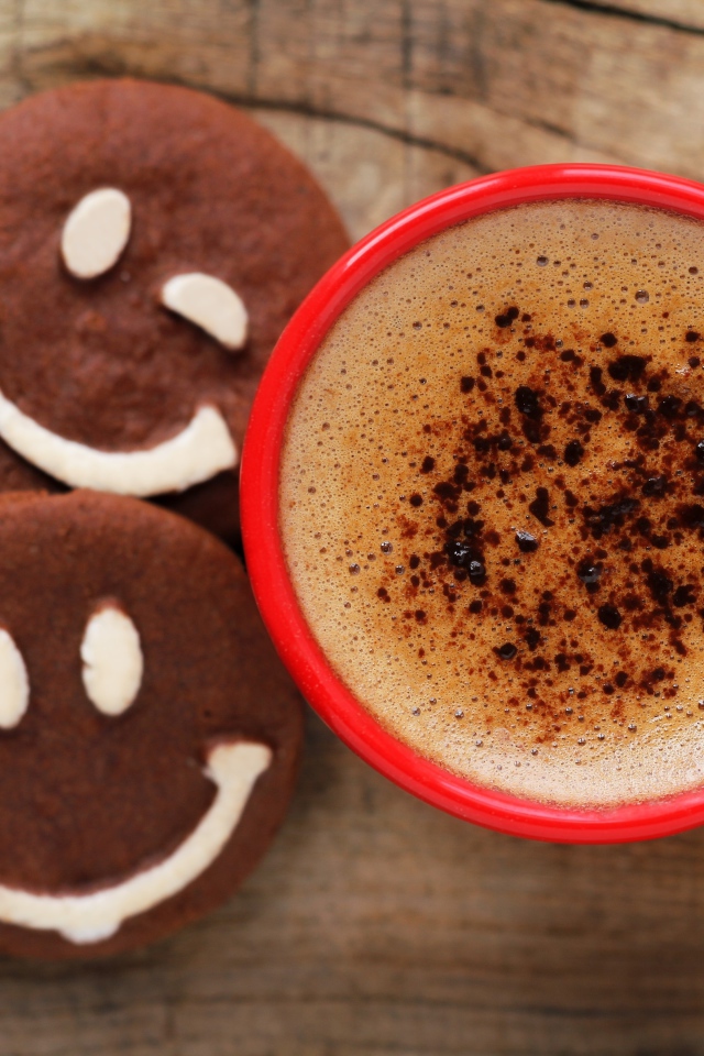 Шоколадное печенье смайлы на столе с чашкой кофе