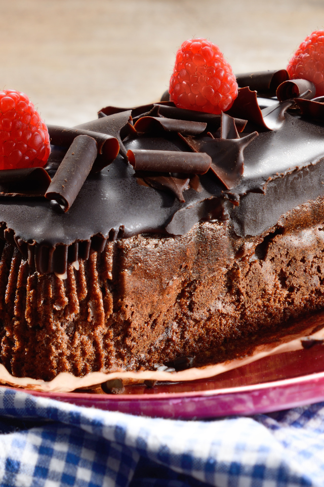Шоколадное пирожное со свежей малиной на тарелке