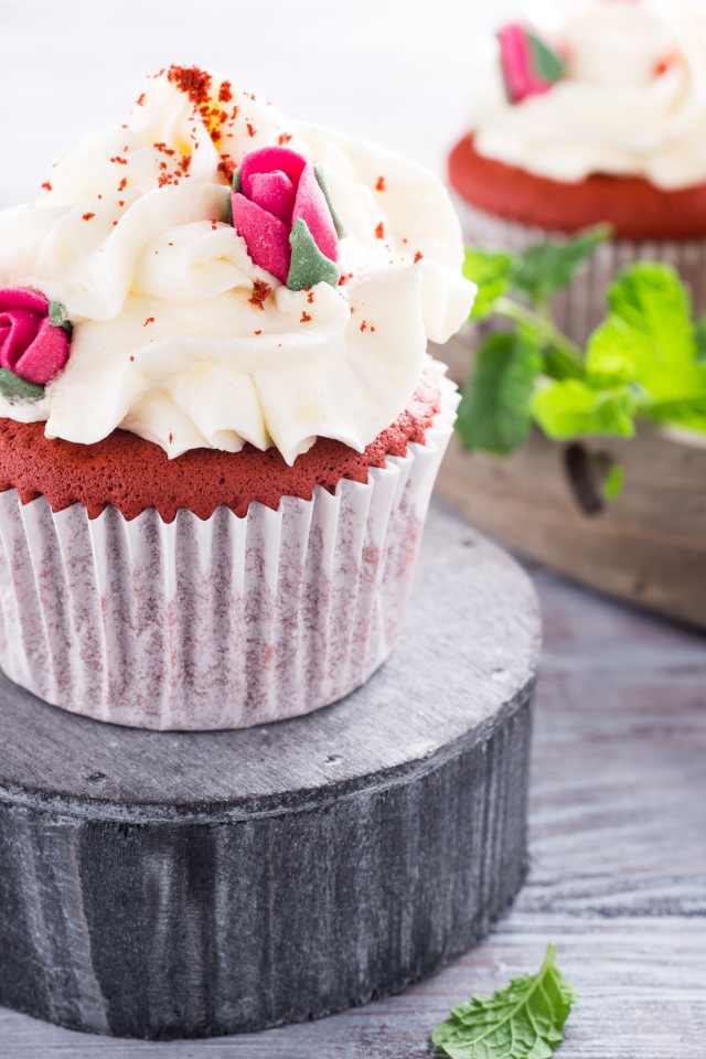 Шоколадный капкейк с кремом и розочками на столе