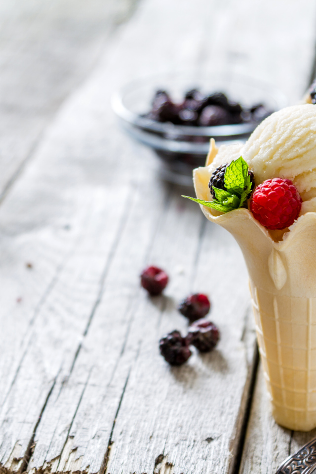 Сливочное мороженое в вафельном стаканчике с ягодами