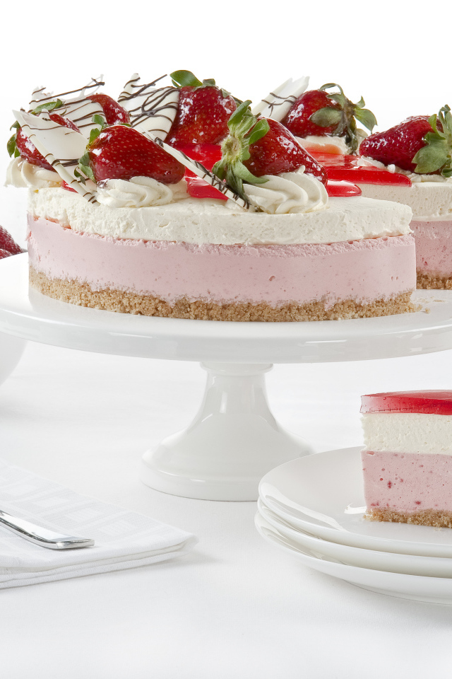 Вкусный торт с суфле, белым шоколадом и ягодами клубники на белом фоне