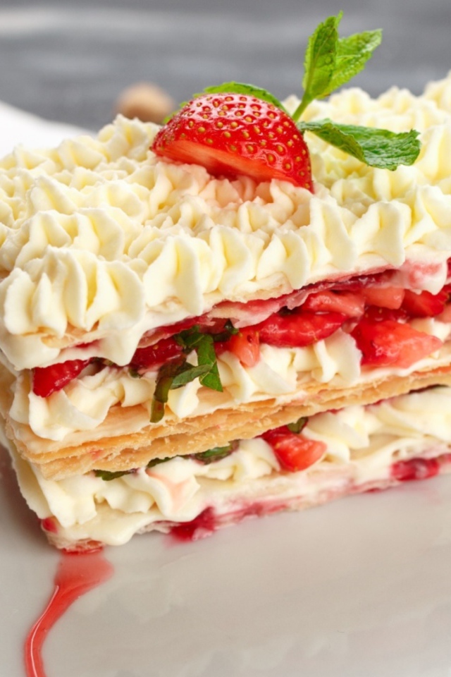 Вкусное сладкое пирожное с кремом и клубникой