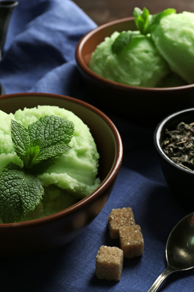 Зеленое мятное мороженое и кусочки сахара на столе 