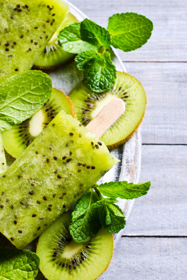 Мороженое с киви и листиками мяты на деревянном столе