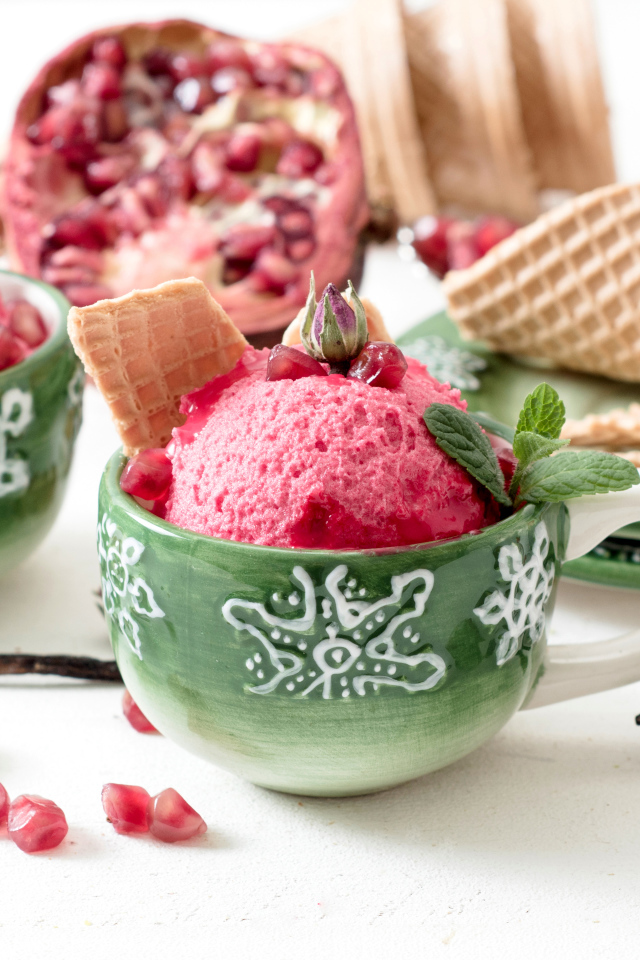 Мороженое с зернами граната в зеленых чашках на столе