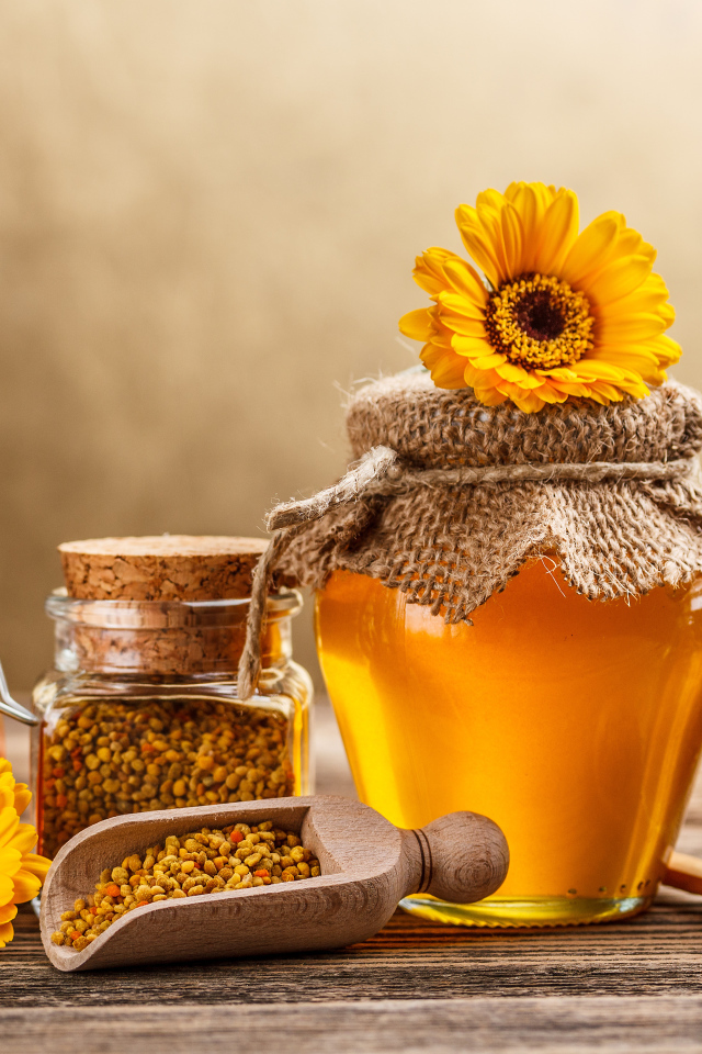 Баночки с медом, пыльцой и прополисом на столе