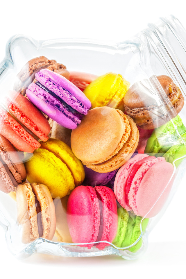 Разноцветные макаруны в стеклянной банке на белом фоне