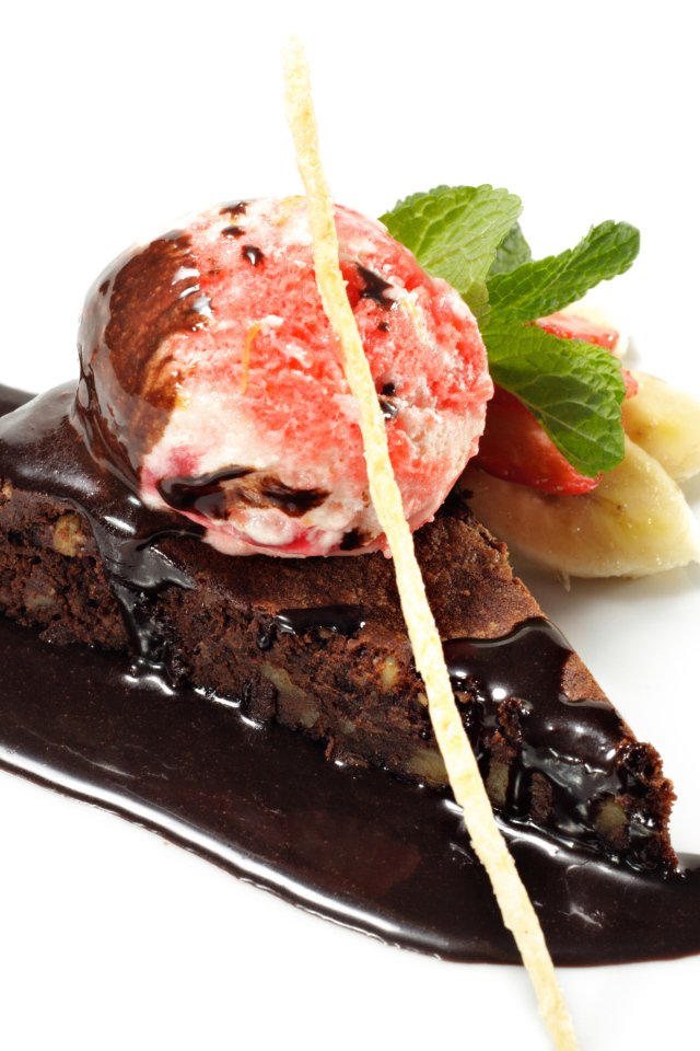 Кусок пирожного с шоколадом и шариком мороженого на белом фоне