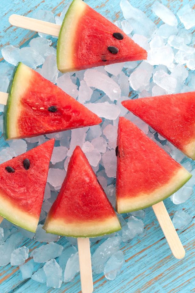 Кусочки арбуза на палочке лежат на льду