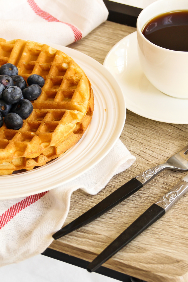 Сладкие вафли с черникой и чашкой кофе на завтрак