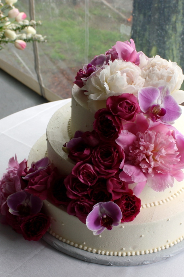 Большой свадебный торт украшен живыми цветами