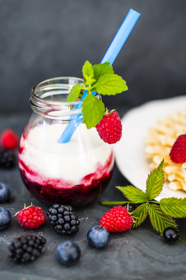 Тонкие хрустящие вафли на столе с ягодами и коктейлем