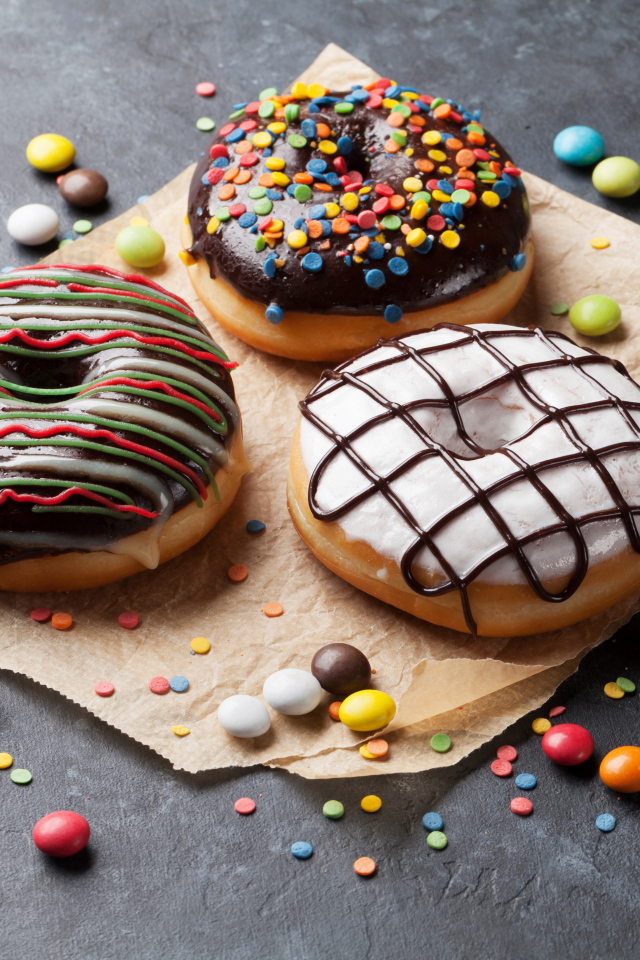 Три аппетитных сладких пончика с конфетами 