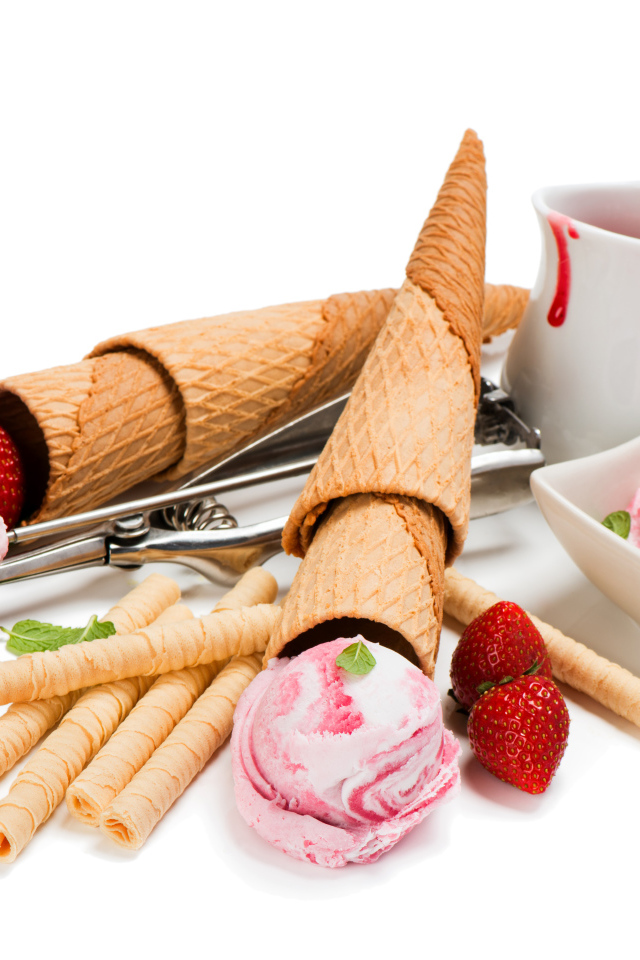 Вафельные трубочки с шариками мороженого и свежей клубникой на белом фоне