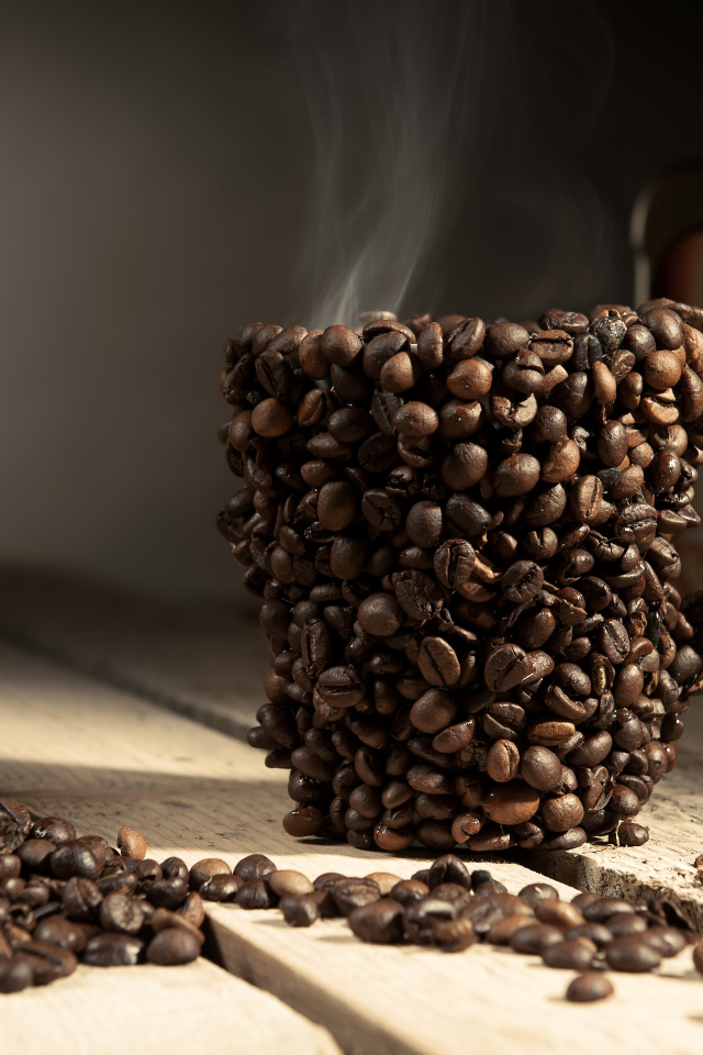 Чашка из кофейных зерен с горячим кофе 