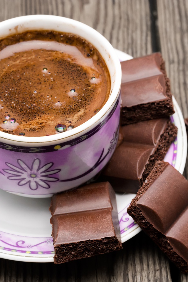 Чашка кофе с черным пористым шоколадом 