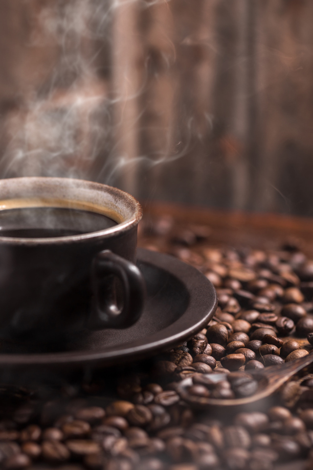 Чашка горячего ароматного кофе с кофейными зернами