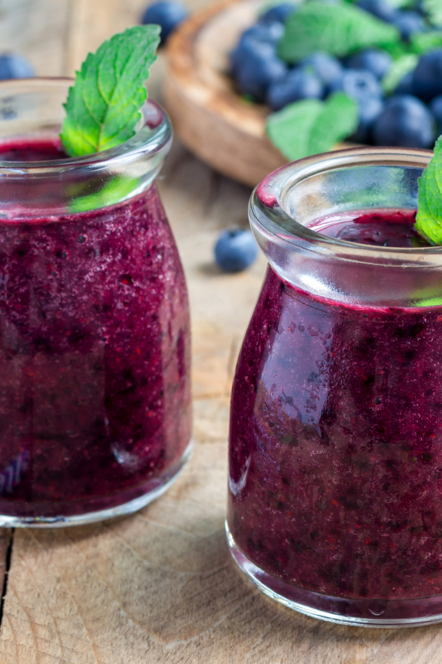 Вкусный черничный смузи с ягодами свежей черники на столе