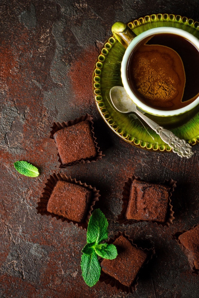 Ароматный кофе в чашке с шоколадными конфетами 