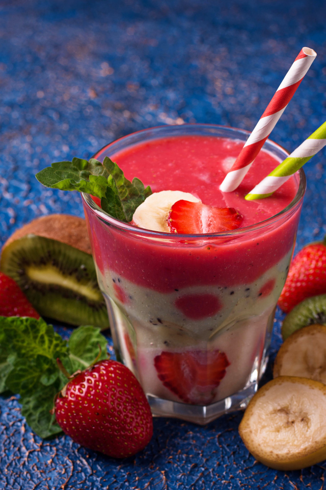 Фруктовый коктейль с клубникой, бананом и киви в стакане с трубочками