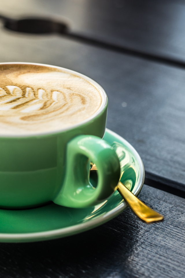 Зеленая чашка капучино с белой пенкой 