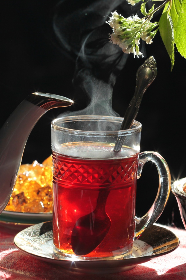 Горячий чай в стеклянной чашке на столе