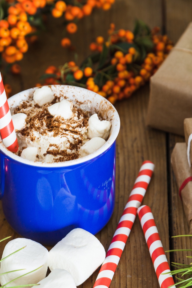 Сладкий напиток с маршмеллоу на столе с подарками на Новый год