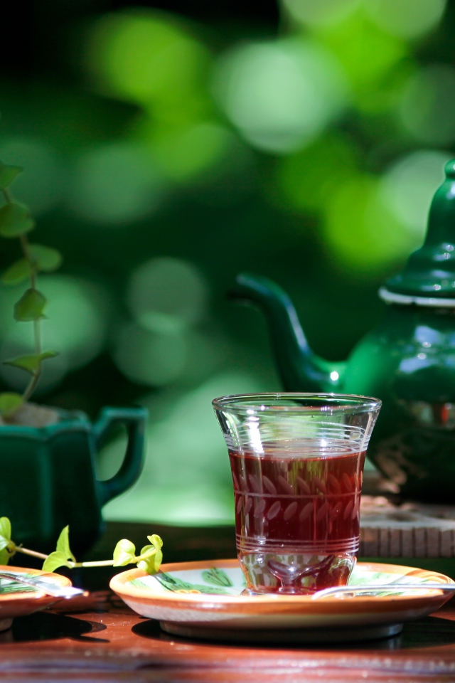 Две чашки чая и зеленый чайник на столе 