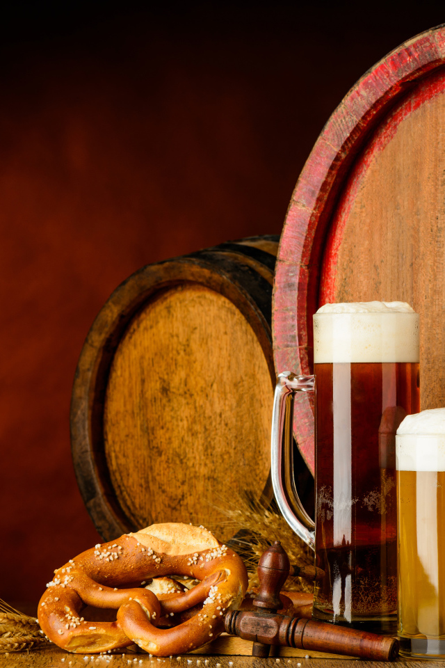 Два бокала пива и выпечка у пивных бочек