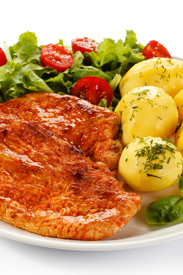 Аппетитные отбивные с вареным картофелем и салатом на белой тарелке