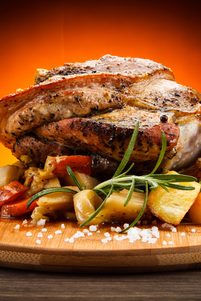 Аппетитный сочный кусок мяса с овощами и солью на разделочной доске